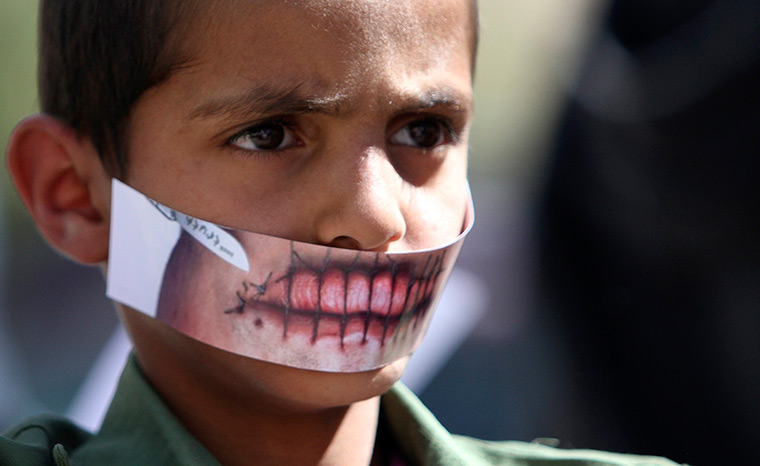 Sana'a, Yemen: A boy wears a paper mask to depict silence