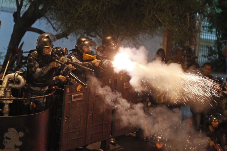 Riot police fire rubber bullets at demonstrator during clashes near Guanabara Palace in Rio de Janeiro