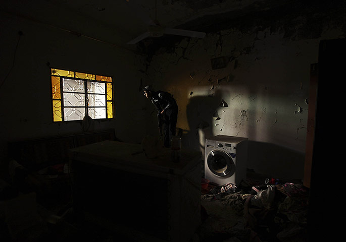 A Free Syrian Army fighter takes position inside a house in Deir al-Zor